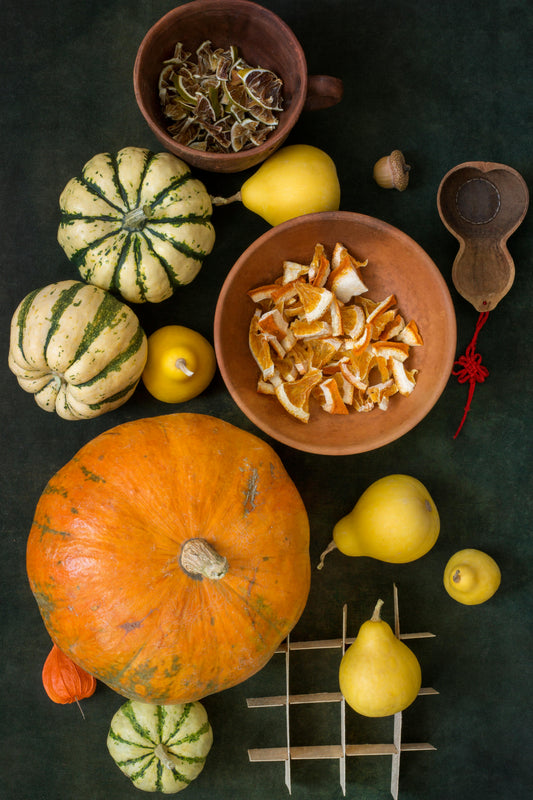 Autumn pumpkins and seasonal fruits on a dark table symbolizing balance and mindfulness during the holiday season