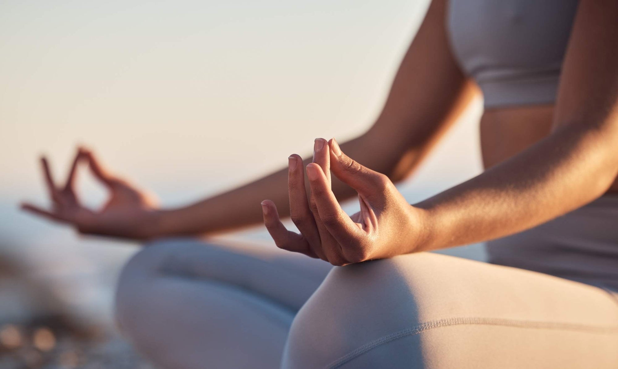 Woman in a seated meditation pose focusing on mindfulness and self-care before a fitness session